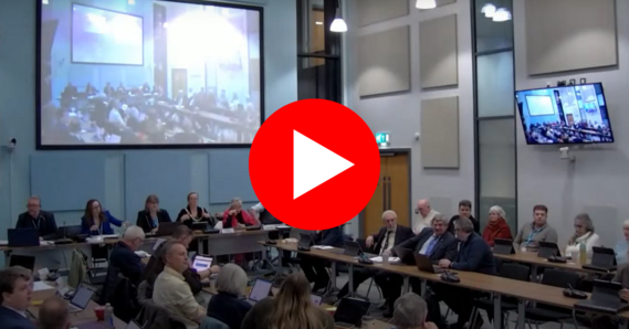 Play button on a screenshot of an Extraordinary Council meeting