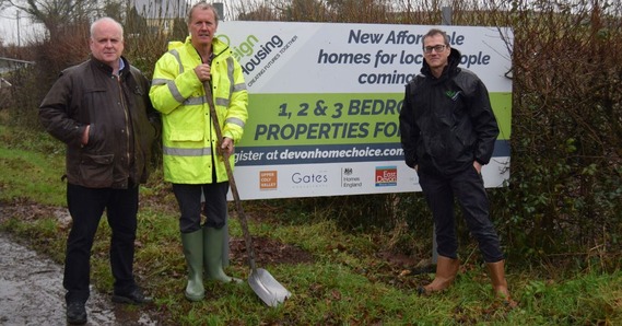 Councillor Paul Arnott, Willy Rich, and Tom Woodman, stood next to a signpost advertising affordable housing in Northleigh
