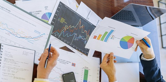 Business charts and graphs with two hands