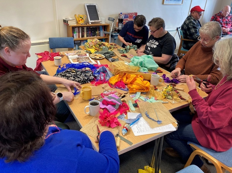 Residents gathered around a table doing some craft activities