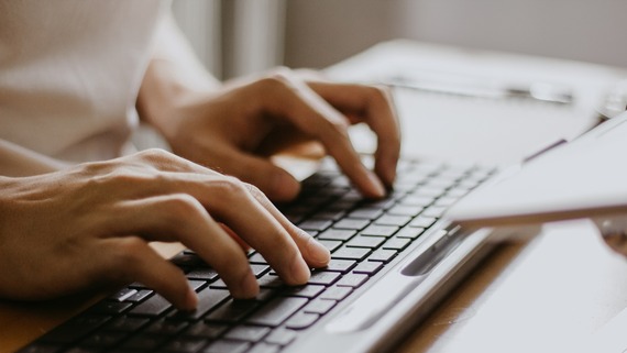 Hands typing on a computer keyboard