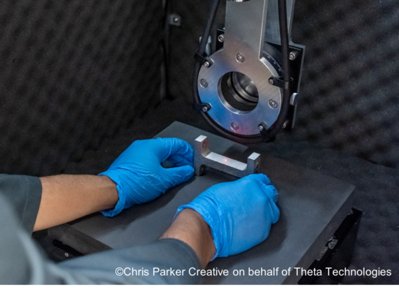 Gloved hands operate a laser machine