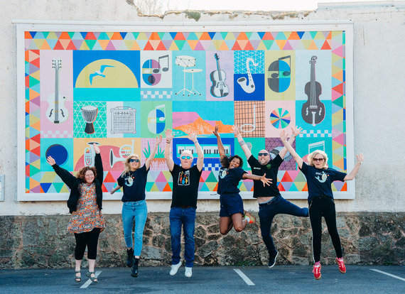 People jumping in front of the Vibrations in the Valley artwork at Sidmouth Wallspace