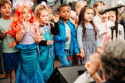 Group of children on stage with a microphone