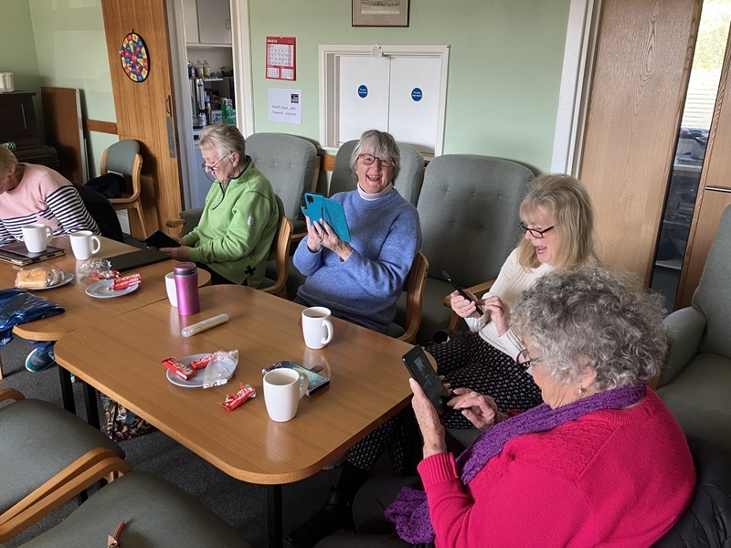 A group of residents sat round a table learning how to use their smartphones