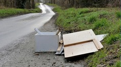 Fly-tipped waste on the side of a country road