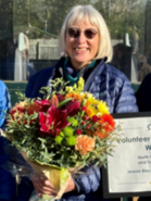 Jeanie Blackall who won a Volunteer Award, with flowers and a certificate