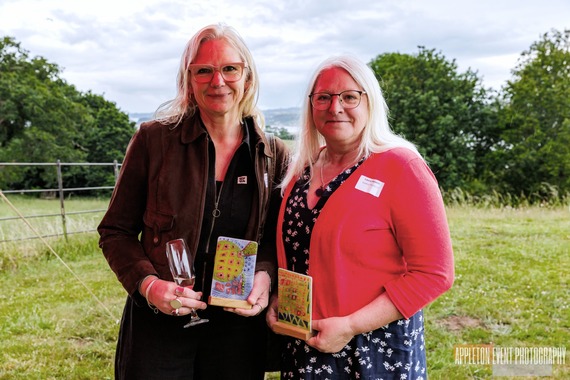 Louise Cole and Laura Hewitt holding their awards, with A La Ronde grounds in the background