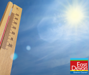 A thermometer with the sun in a blue sky