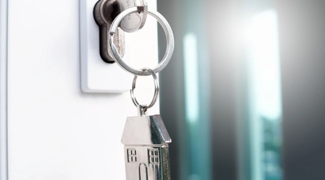 Key in a lock and a silver house keyring