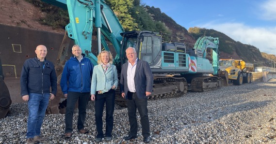 Henry Middleton, Cllrs Marcus Hartnell, Paula Fernley, and Paul Arnott on Seaton beach with diggers behind