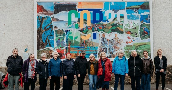 COP 30 billboard at Sidmouth Wallspace, with some of the participating artists and artist and project coordinator