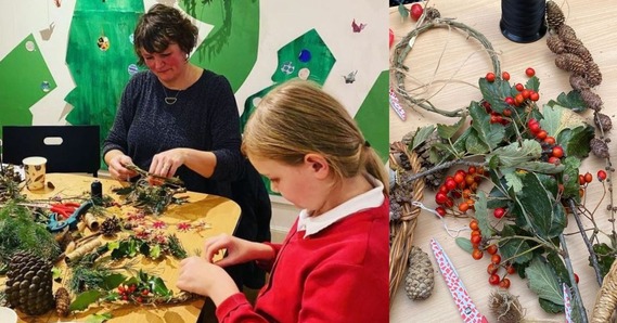 An adult and a child making wreaths. Leaves, berries, and pinecones