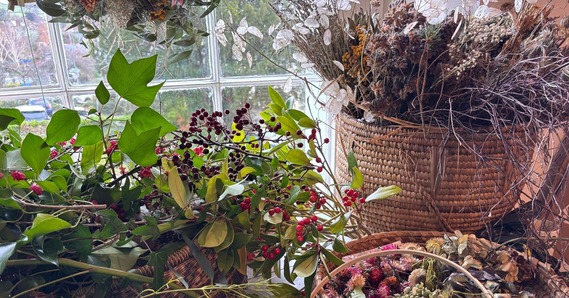 Baskets of berries, leaves, and dried flowers on a window sill