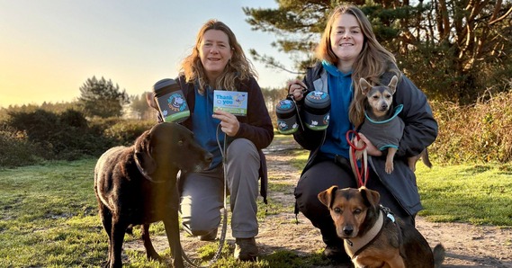 Trish and Julie from Devon Loves Dogs, with three dogs, and the prizes