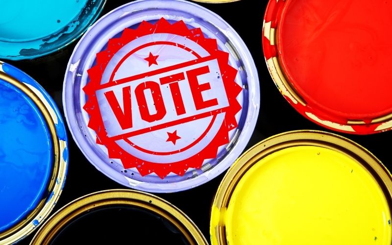 A selection of brightly coloured tins of paints with the word "vote"
