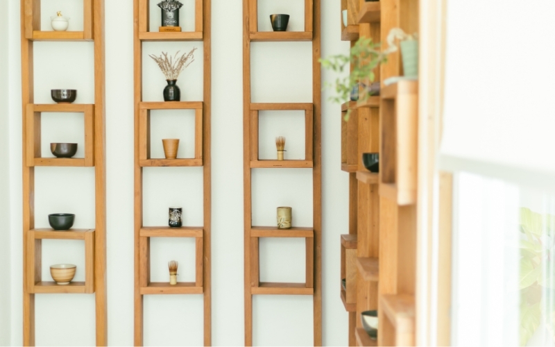 ladder shelves on a wall with plant pots on them
