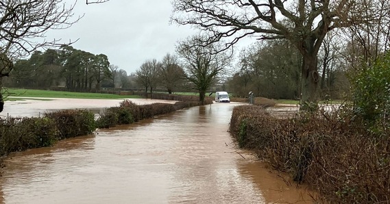 A van stuck in floodwater in a road out of Ottery