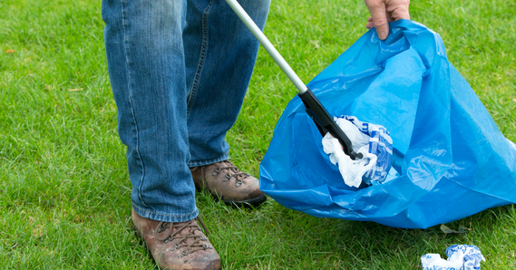 Person picking up litter and putting it in a bag