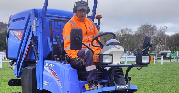 StreetScene worker wearing hi vis sat on a mower