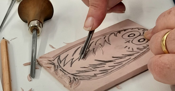 An owl design being carved into a print