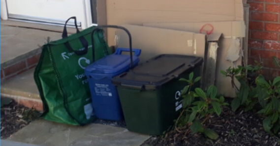 Cardboard stacked behind recycling containers