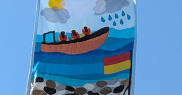Lifeboats flag with a boat, lifeguards, a flag, pebbles, rain, clouds, and sunshine