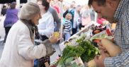 People at market stalls with fresh produce