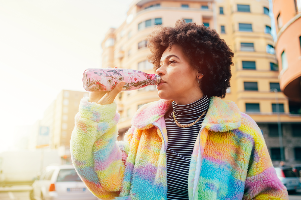 Woman drinking from metal reusable bottle