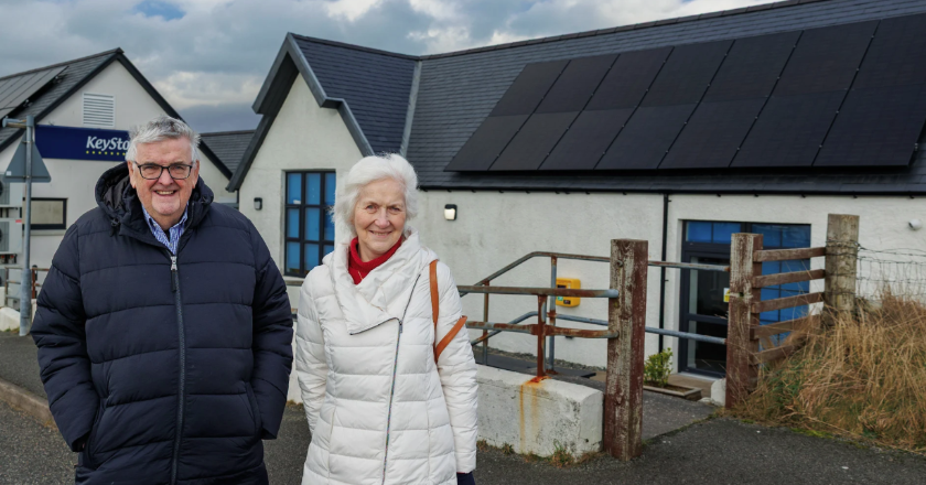 People standing next to solar panels