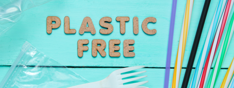 Words plastic free on blue background with plastic bag and plastic straws