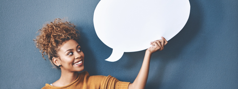 Woman holding up a bubble speech symbol