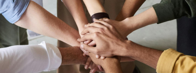 People's hands in a circle touching