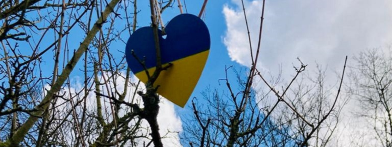 Ukraine flag on a heart shaped decoration hanging from a tree