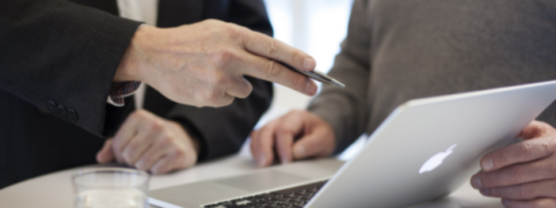 Hand with a pen pointing to an apple screen