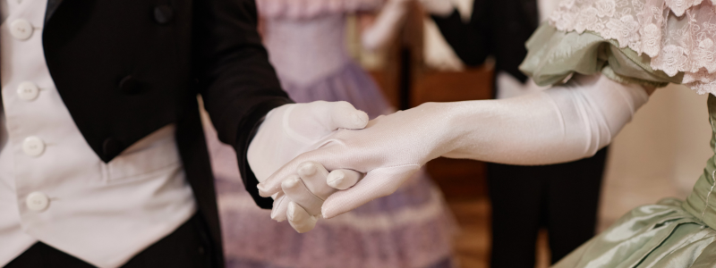 People holding hands in white gloves and Regency dress