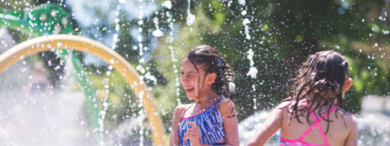 Children playing and splashing in water at a play park