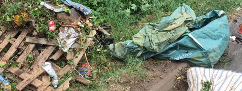 Various fly tipped rubbish including a wooden palette, a mattress and plastic bag