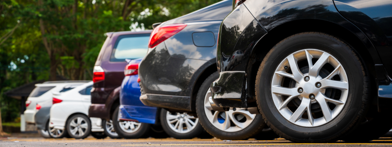 Six cars of differing size and colour lined up in a car park