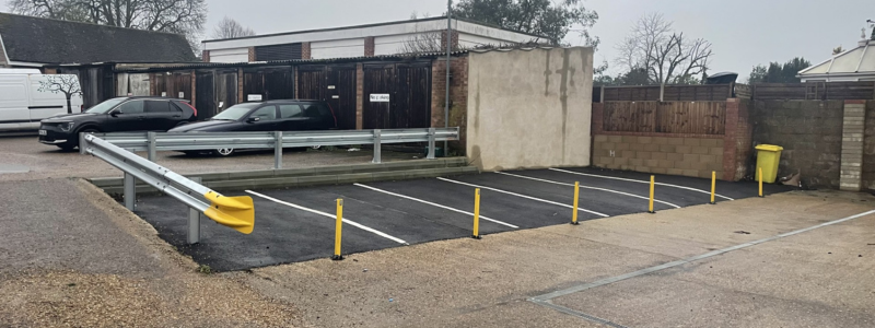 Car parking spaces in front of a metal barrier