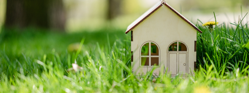 small wooden model of house on green grass