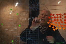 Women stood behind transparent glass with tactical notations on, writing RAF Holmpton.