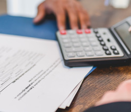 person looking at a document and calculator