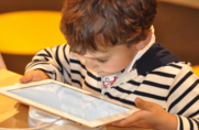 A photo of a child on a tablet