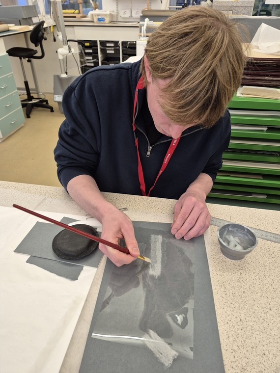 A person doing conservation work on a historical document