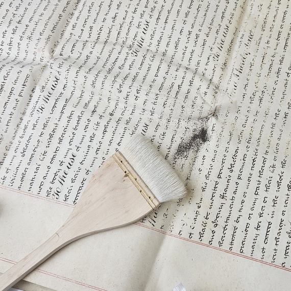 Using a soft brush to remove the ink dust