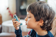 A photo of a child holding an asthma inhaler