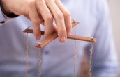 A photo of a person holding marionette strings