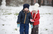 A photo of two children smiling in the snow