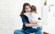 A photo of a child and an adult hugging